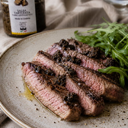 Salsa Tartufata servita con una tagliata di manzo a fette, ideale per esaltare il sapore della carne.