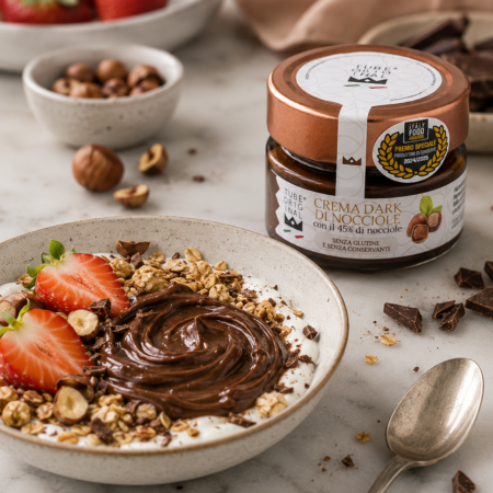 Crema Dark di Nocciole Tube Original con il 45% di nocciole servita su yogurt greco con granola, fragole fresche e nocciole.