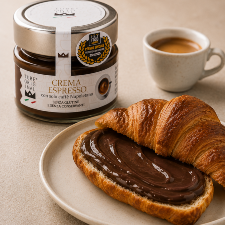 Crema Espresso Tube Original spalmata su un croissant, accompagnata da una tazzina di espresso.