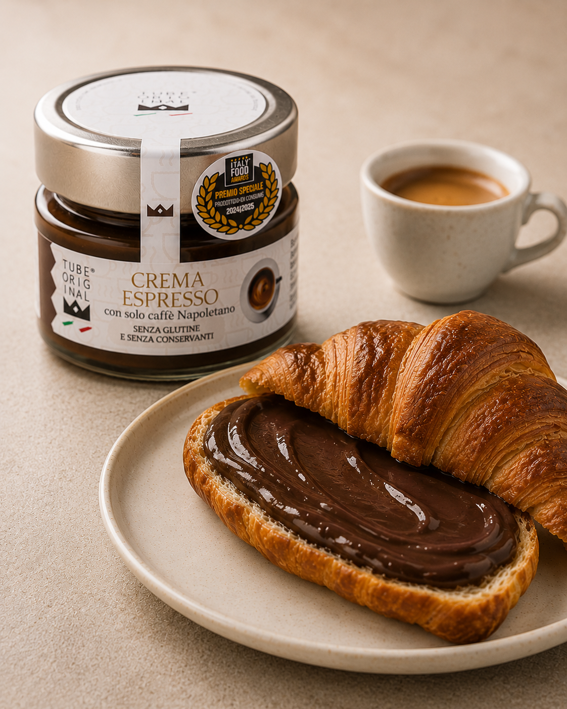Crema Espresso Tube Original spalmata su un croissant, accompagnata da una tazzina di espresso.