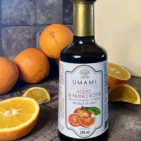Bottiglia di aceto di arance rosse Umami con arance fresche