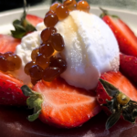 Dessert gourmet con gel ottenuto dagli scarti delle fragole aromatizzati al Limone nero, gelato fiordilatte, fragole fresche e perle di aceto balsamico di abete dei Pirenei